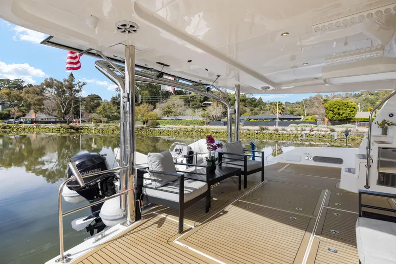 Slide: The Image of Luxurious 2015 Leopard 58 yacht deck with seating, overlooking serene waters and lush greenery. - 16