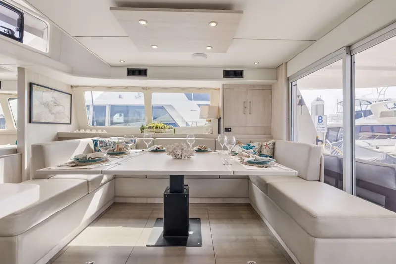 Slide: The Image of Luxurious dining area on a 2015 Leopard 58 yacht, featuring elegant table settings and panoramic windows. - 26