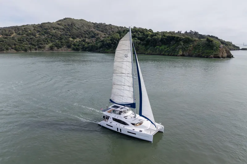 Slide: The Image of Sailing catamaran Leopard 58, 2015 model, cruising near lush green island. - 5