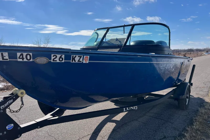 Slide: The Image of 2020 Lund 1675 Adventure Sport boat on trailer, blue exterior, parked on roadside. - 10