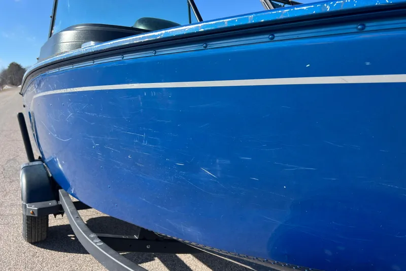 Slide: The Image of 2020 Lund 1675 Adventure Sport boat, blue hull with visible scratches, on a trailer. - 46