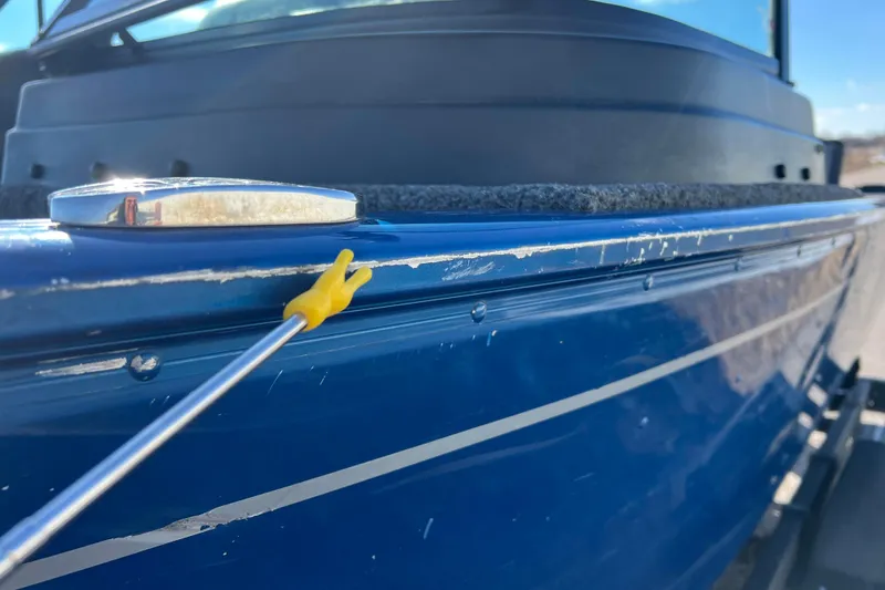 Slide: The Image of 2020 Lund 1675 Adventure Sport boat with visible paint scratches on the blue hull. - 56