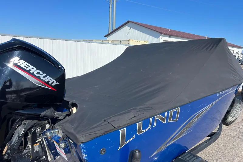 Slide: The Image of 2020 Lund 1675 Adventure Sport boat with Mercury engine, covered and parked outdoors. - 7