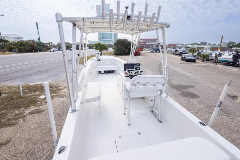 Slide: The Image of 2017 Andros Tarpon 26 boat with T-top and console, parked near a marina. - 17