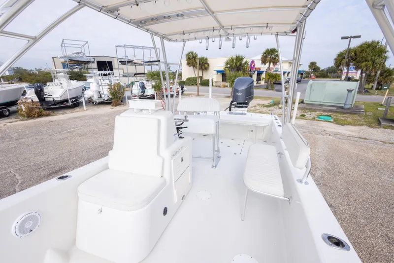 Slide: The Image of 2017 Andros Tarpon 26 boat with seating and canopy in a marina setting. - 18