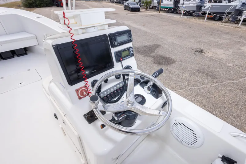 Slide: The Image of 2017 Andros Tarpon 26 boat helm with steering wheel and navigation controls. - 22
