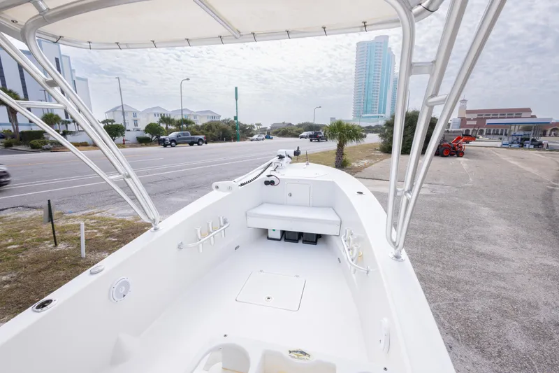 Slide: The Image of 2017 Andros Tarpon 26 boat with T-top, parked near a road and buildings. - 23