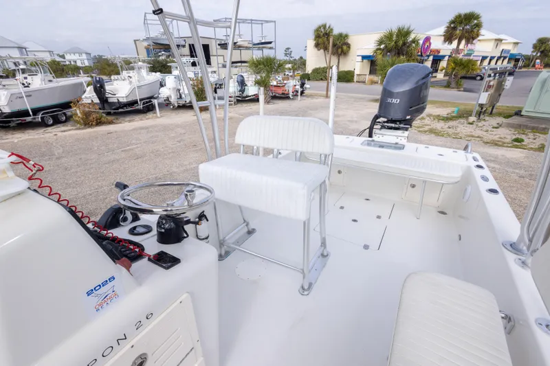 Slide: The Image of 2017 Andros Tarpon 26 boat interior with seating and steering wheel, parked outdoors. - 25