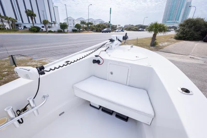Slide: The Image of 2017 Andros Tarpon 26 boat with white seating and trolling motor, parked near a coastal road. - 27