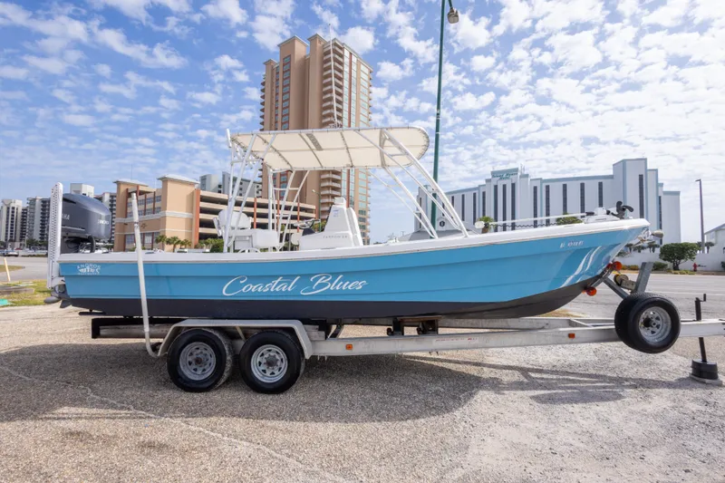 Slide: The Image of 2017 Andros Tarpon 26 boat "Coastal Blues" on trailer, cityscape background. - 31