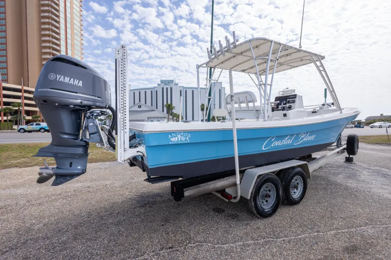 Slide: The Image of 2017 Andros Tarpon 26 boat on trailer with Yamaha engine, labeled "Coastal Blues." - 32