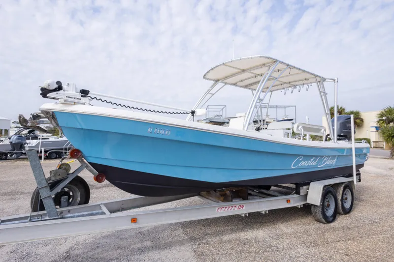 Slide: The Image of 2017 Andros Tarpon 26 boat on trailer, blue hull, parked outdoors. - 35