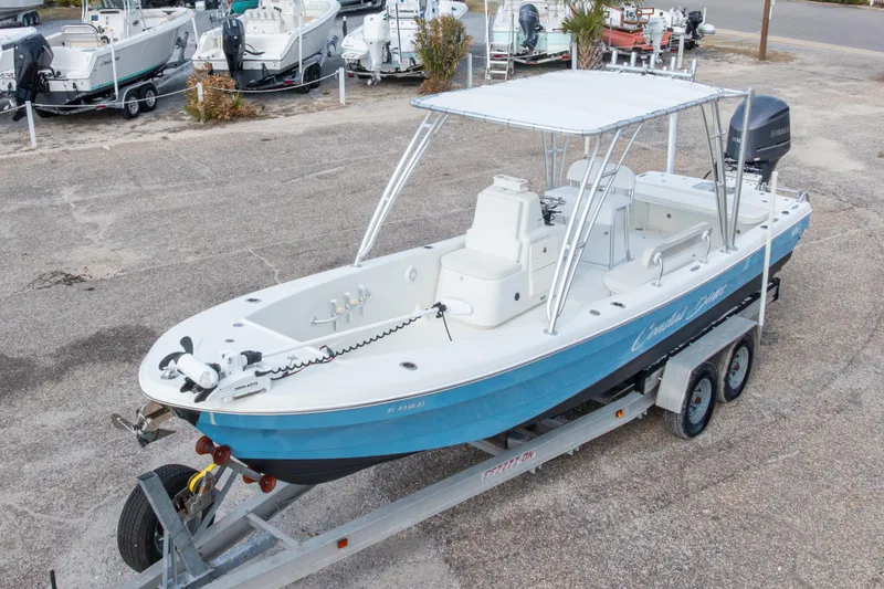 Slide: The Image of 2017 Andros Tarpon 26 boat on trailer, blue hull, parked in a marina. - 11