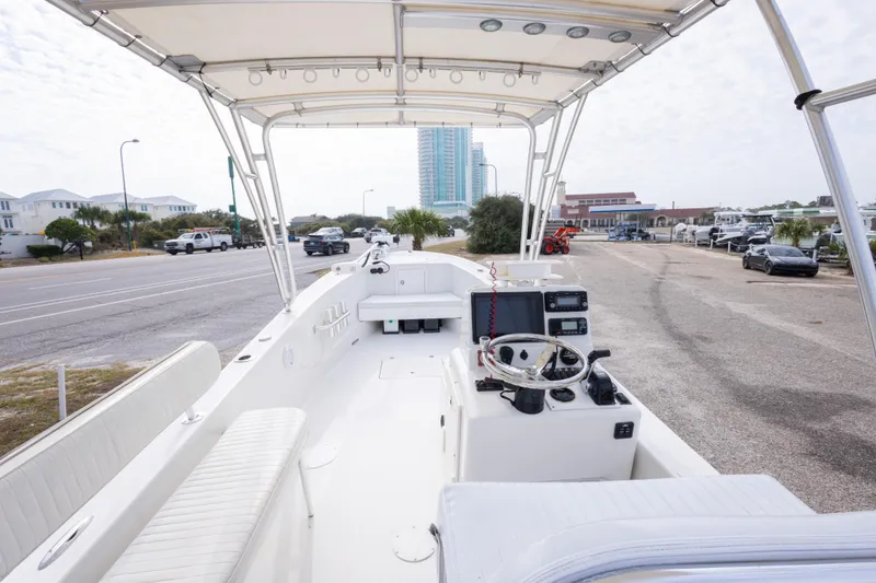 Slide: The Image of 2017 Andros Tarpon 26 boat interior with steering console, parked near a coastal road. - 19