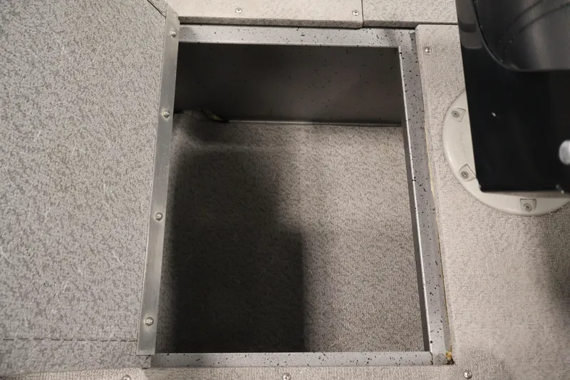 Slide: The Image of 2019 Crestliner 1800 Kodiak SC boat storage compartment with gray carpeted interior. - 20