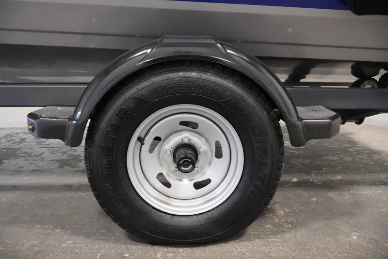 Slide: The Image of Trailer wheel of 2019 Crestliner 1800 Kodiak SC boat, featuring durable tire and fender. - 48