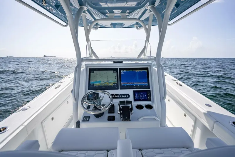 Slide: The Image of 2025 Yellowfin 34 Offshore boat dashboard with navigation screens on open sea. - 10