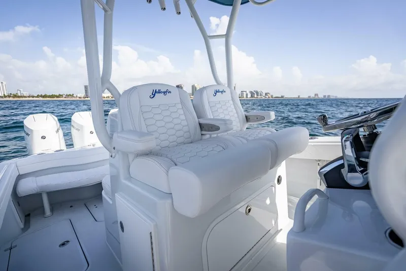 Slide: The Image of 2025 Yellowfin 34 Offshore boat interior with white seating and ocean view. - 13