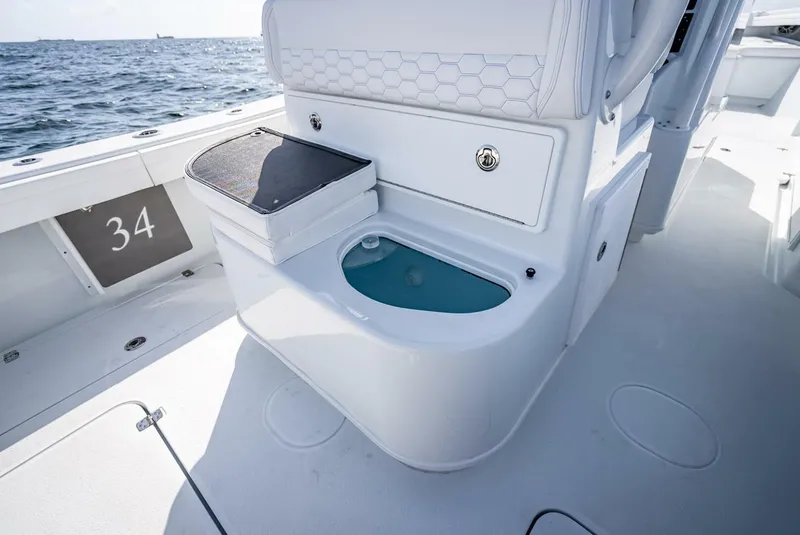 Slide: The Image of 2025 Yellowfin 34 Offshore boat interior with storage and seating, ocean view. - 23