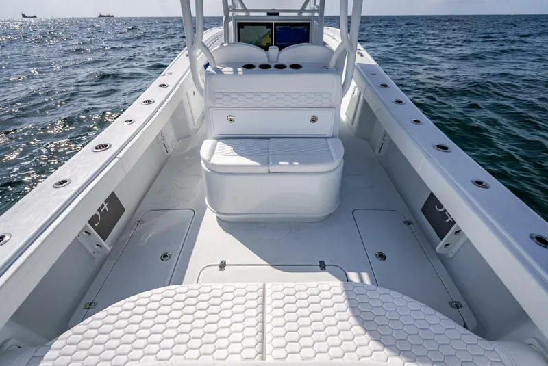 Slide: The Image of 2025 Yellowfin 34 Offshore boat interior with white seating and ocean view. - 28