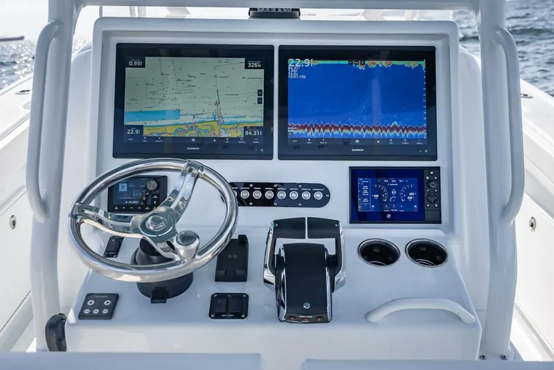 Slide: The Image of 2025 Yellowfin 34 Offshore boat dashboard with navigation screens and steering wheel. - 9
