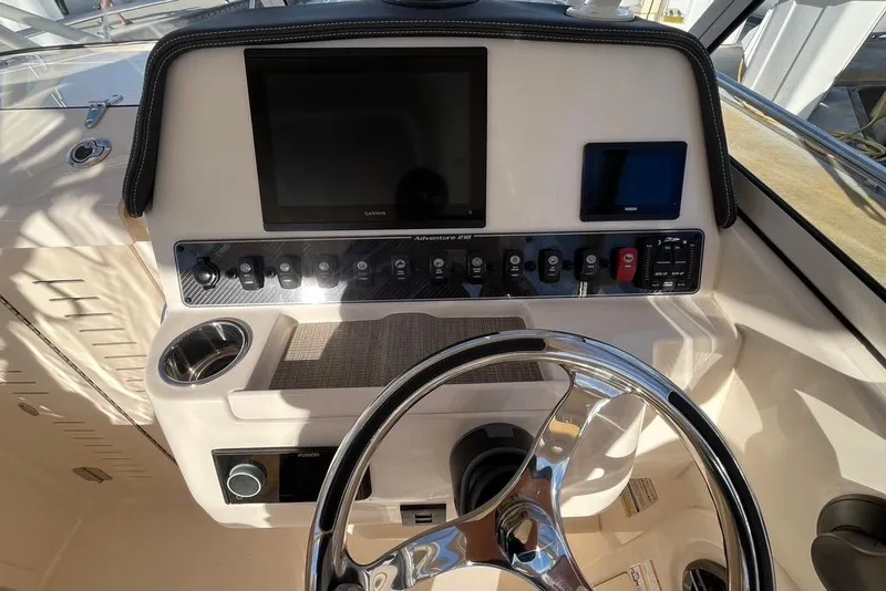 Slide: The Image of 2023 Grady-White Adventure 218 boat interior with steering wheel and captain's seat. - 8