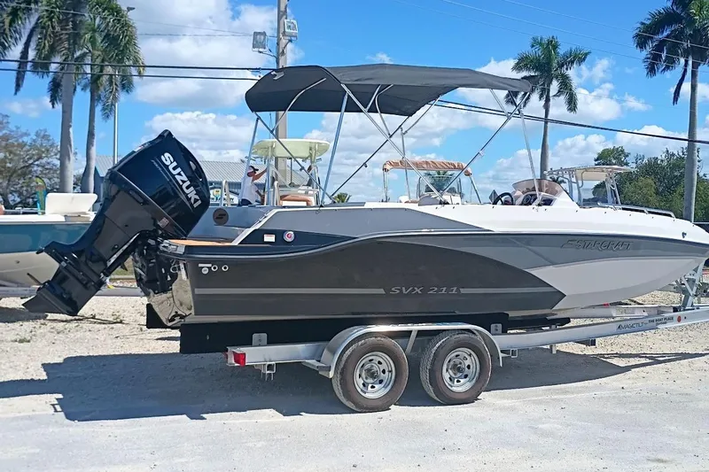 The Image of 2026 Starcraft SVX 211 OB boat on trailer with Suzuki outboard motor, parked outdoors. - 0