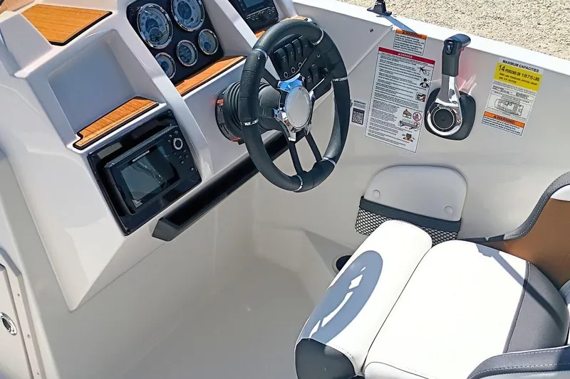 Slide: The Image of 2026 Starcraft SVX 211 OB boat cockpit with steering wheel and control panel. - 13