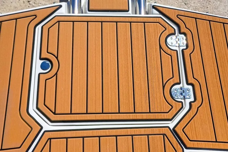 Slide: The Image of Teak-style deck of 2026 Starcraft SVX 211 OB boat, featuring sleek design and metal hinges. - 27