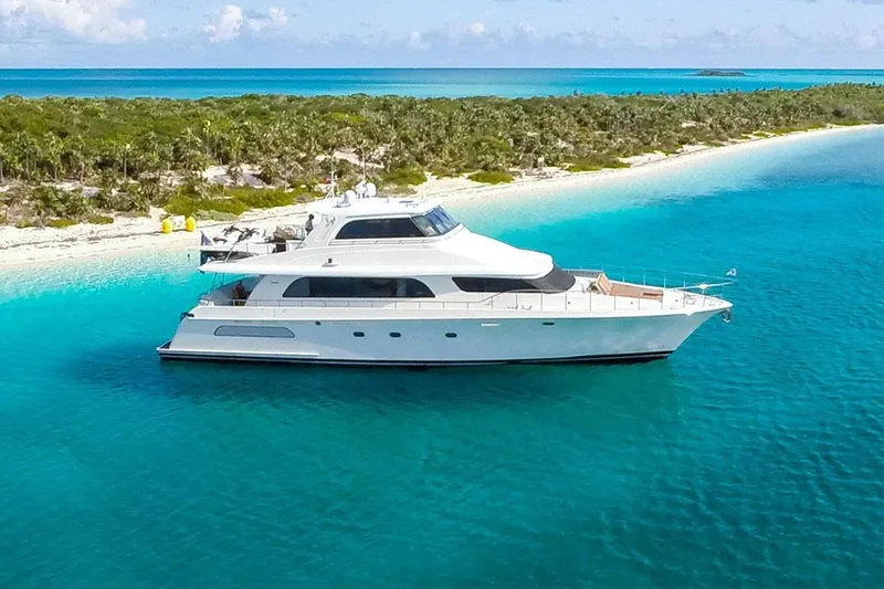 Slide: The Image of 2004 Cheoy Lee 81 Sport Yacht anchored in turquoise waters near a tropical island. - 0