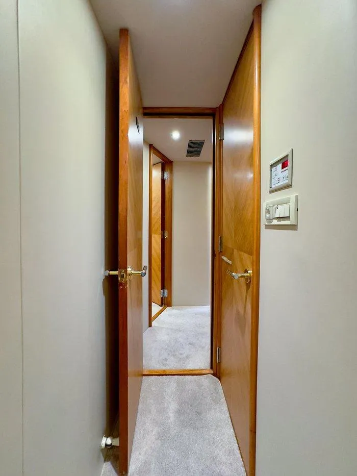 Slide: The Image of Interior hallway of 2004 Cheoy Lee 81 Sport Yacht with wooden doors and carpeted floor. - 29