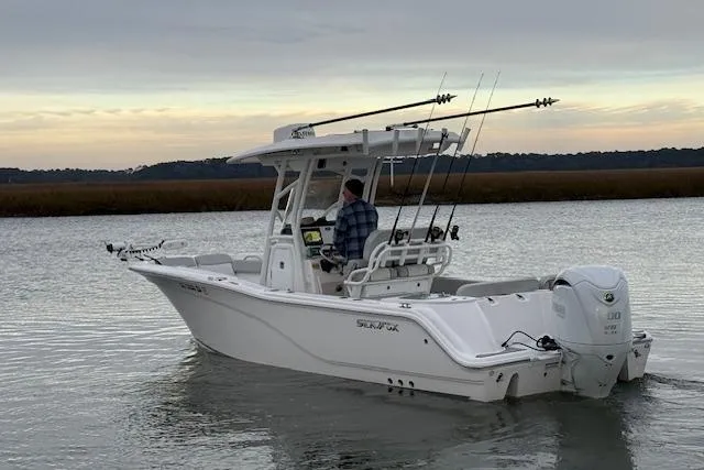 Slide: The Image of 2023 Sea Fox 248 Commander boat on calm water, equipped for fishing. - 2