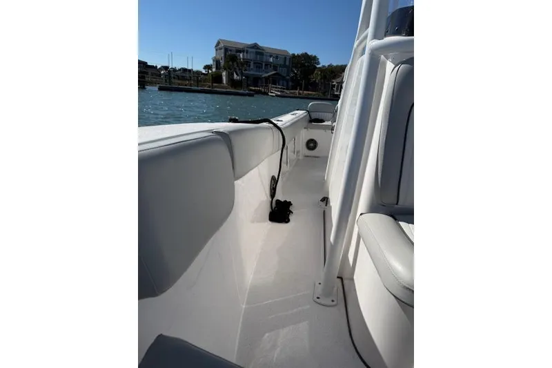 Slide: The Image of 2023 Sea Fox 248 Commander boat interior with white seating and coastal view. - 36