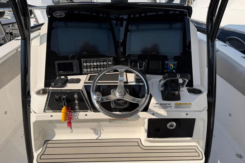 Slide: The Image of 2020 Sea Fox 328 Commander boat dashboard with steering wheel and navigation controls. - 9