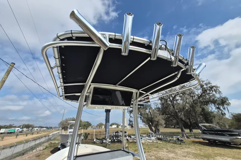 Slide: The Image of 2026 May-Craft 238 CC boat with T-top and rod holders under blue sky. - 8