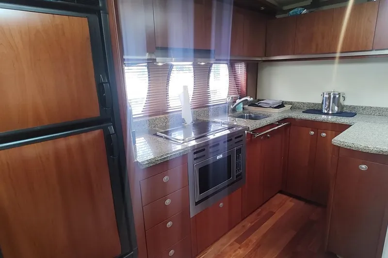 Slide: The Image of Luxurious kitchen interior of 2006 Sea Ray 48 Sundancer yacht with wood cabinetry and modern appliances. - 16