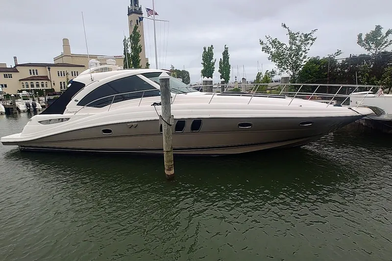 Slide: The Image of 2006 Sea Ray 48 Sundancer yacht docked in a marina, overcast sky. - 3