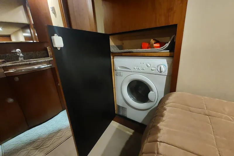 Slide: The Image of Compact laundry area inside 2006 Sea Ray 48 Sundancer yacht, featuring a built-in washing machine. - 34