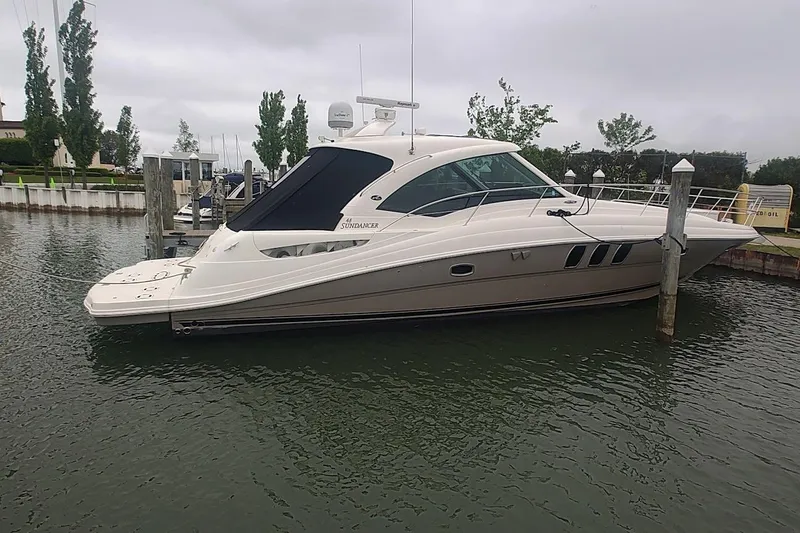 Slide: The Image of 2006 Sea Ray 48 Sundancer yacht docked in a marina on a cloudy day. - 4