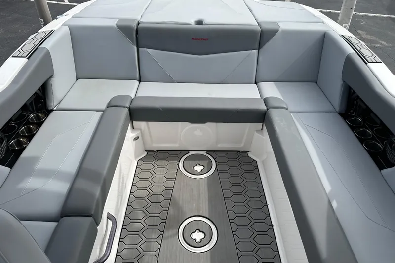 Slide: The Image of 2023 MasterCraft NXT22 boat interior with gray seating and hexagonal floor design. - 4