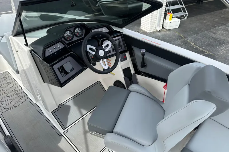 Slide: The Image of 2023 MasterCraft NXT22 boat interior with steering wheel and dashboard controls. - 6