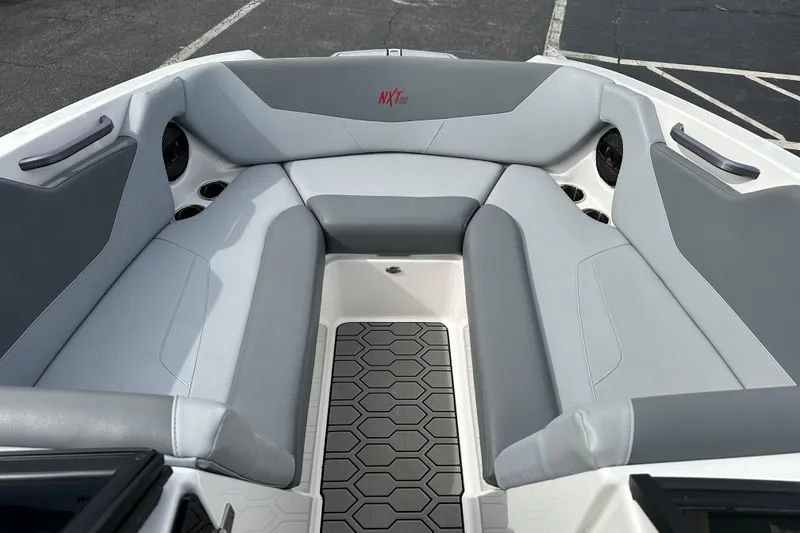 Slide: The Image of 2023 MasterCraft NXT22 boat interior with gray seating and hexagonal floor design. - 7