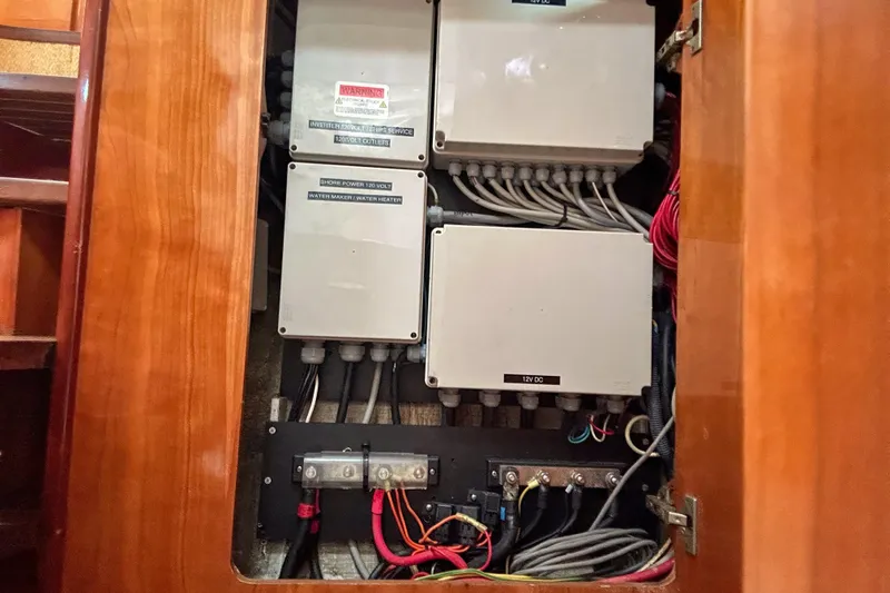 Slide: The Image of Electrical panel inside a 2001 Privilege 435 yacht, showcasing wiring and circuit boxes. - 46