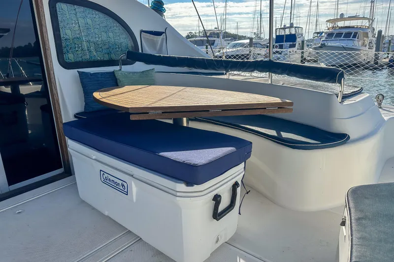 Slide: The Image of Outdoor seating area on 2001 Privilege 435 yacht with wooden table and blue cushions. - 8