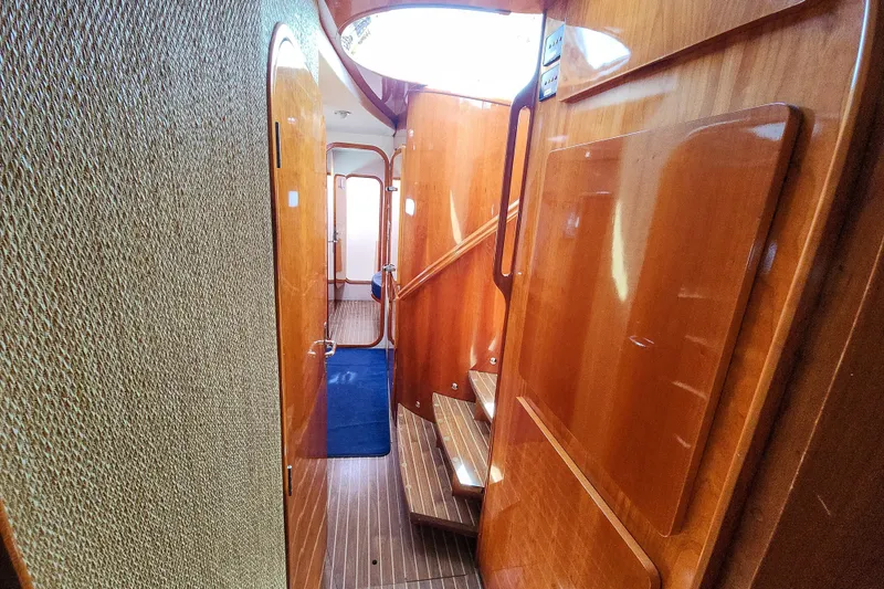 Slide: The Image of Luxurious wooden interior of 2001 Privilege 435 yacht with blue carpeted hallway. - 80