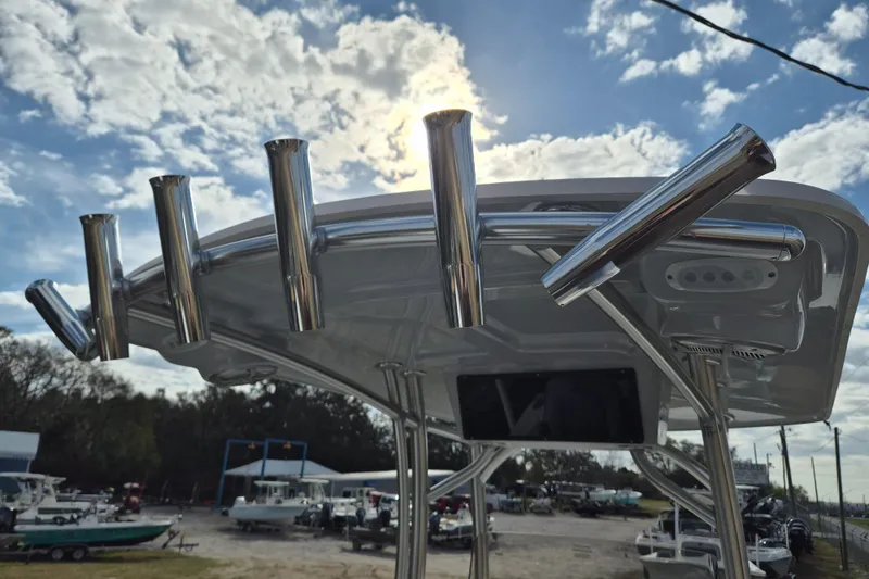 Slide: The Image of 2026 Defiance Catalina 240 boat with rod holders under a cloudy sky. - 15