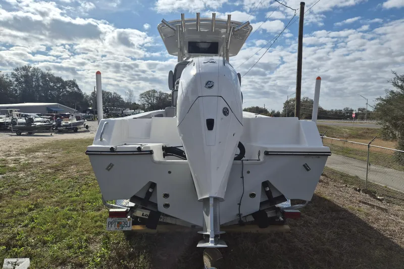 Slide: The Image of 2026 Defiance Catalina 240 boat with outboard motor, parked on grass under cloudy sky. - 5
