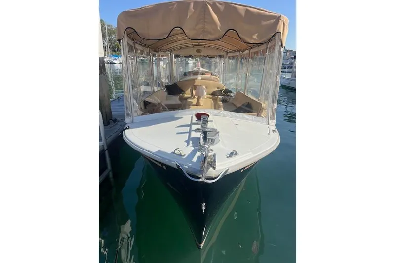 Slide: The Image of 2002 Duffy Classic 21 boat docked with tan canopy and clear side panels. - 2