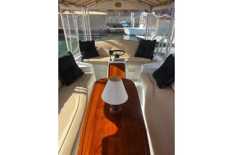 Slide: The Image of Interior of a 2002 Duffy Classic 21 boat with beige seating and a wooden table. - 7