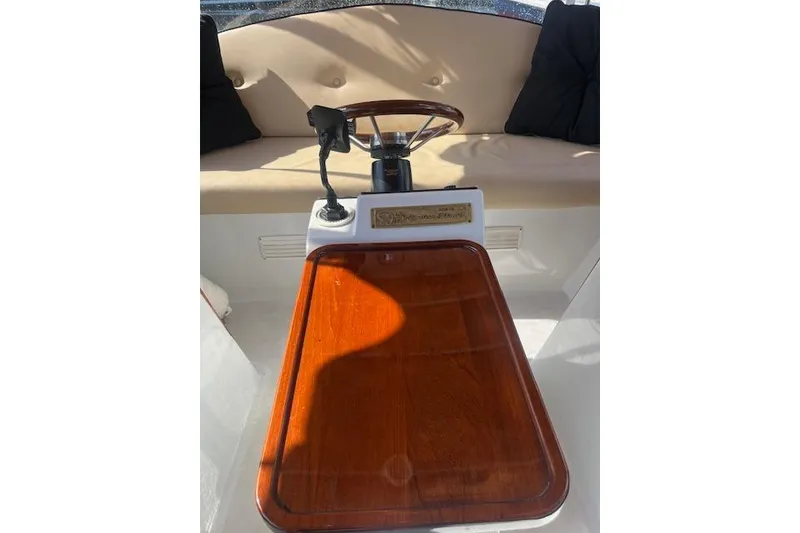 Slide: The Image of Interior of a 2002 Duffy Classic 21 boat with wooden table and steering wheel. - 8